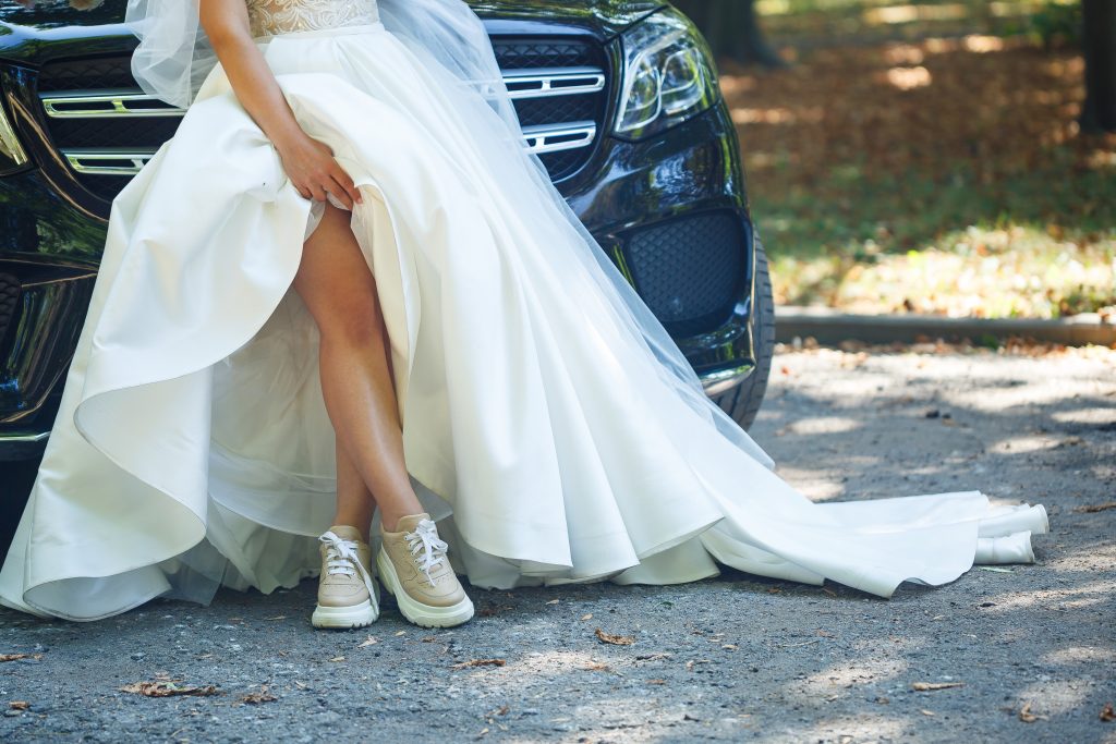 Bride in a white dress and sneakers on a wedding day