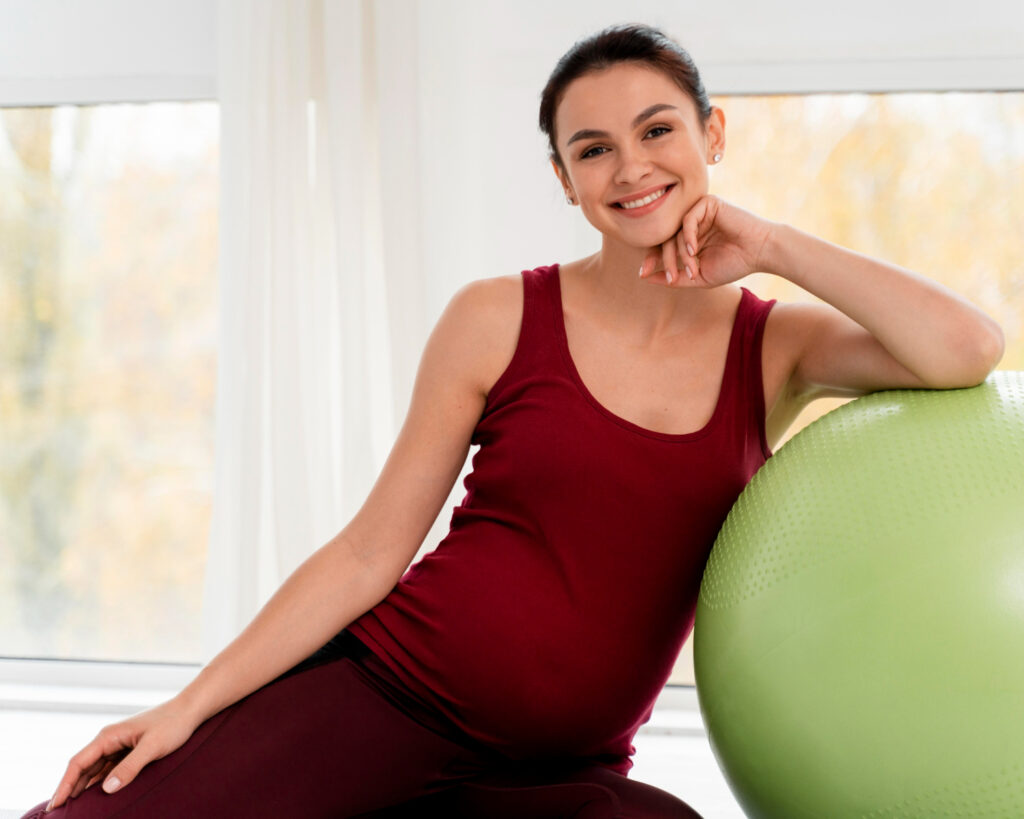 pregnant woman posing fitness ball